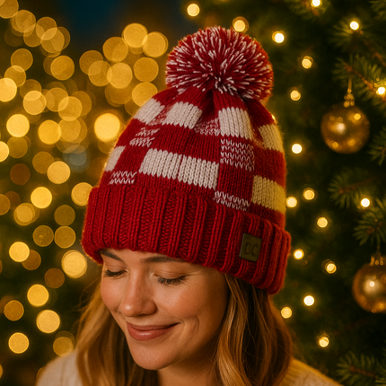 Woman wearing a red and white checkered knit hat in front of a Christmas tree with lights.